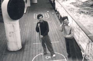Two young men playing on the deck of a boat, from the top level. 