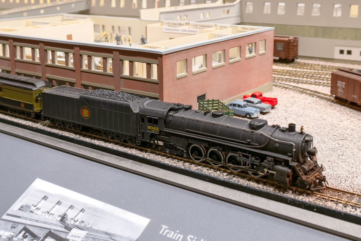  A model train in front of a miniature brick building.